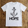 White t-shirt with anchor and 'HOPE' text on a wooden surface