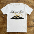 White t-shirt with mountain and sun design on a wooden surface